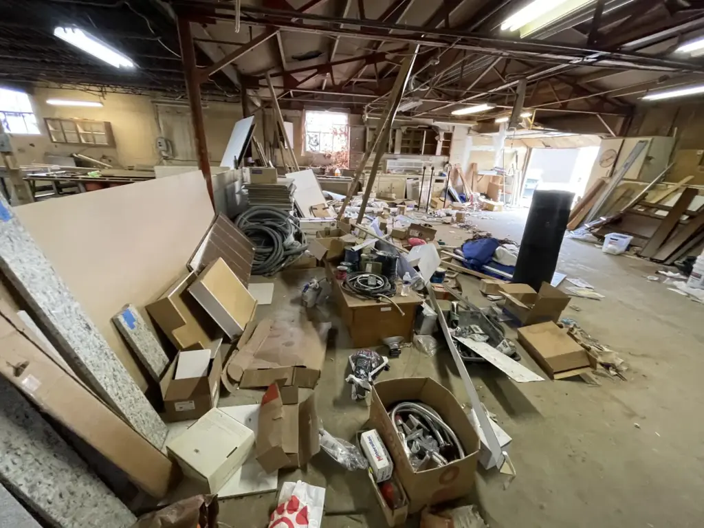 Before photo of debris in a commercial warehouse cleanout by Iron Bear & Co.
