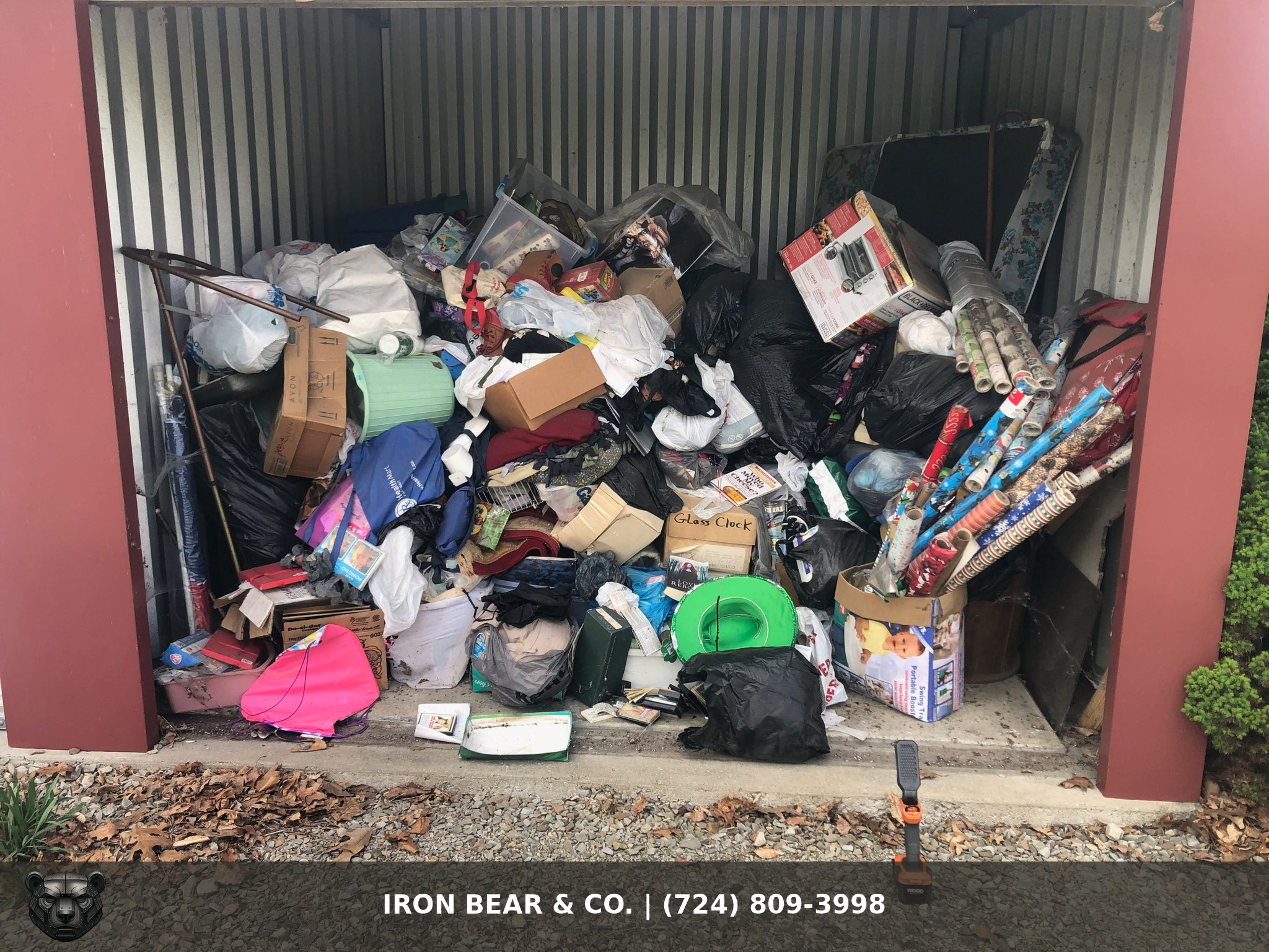 Packed self-storage unit full of boxes, bags, and household items before an Iron Bear & Co. storage unit cleanout